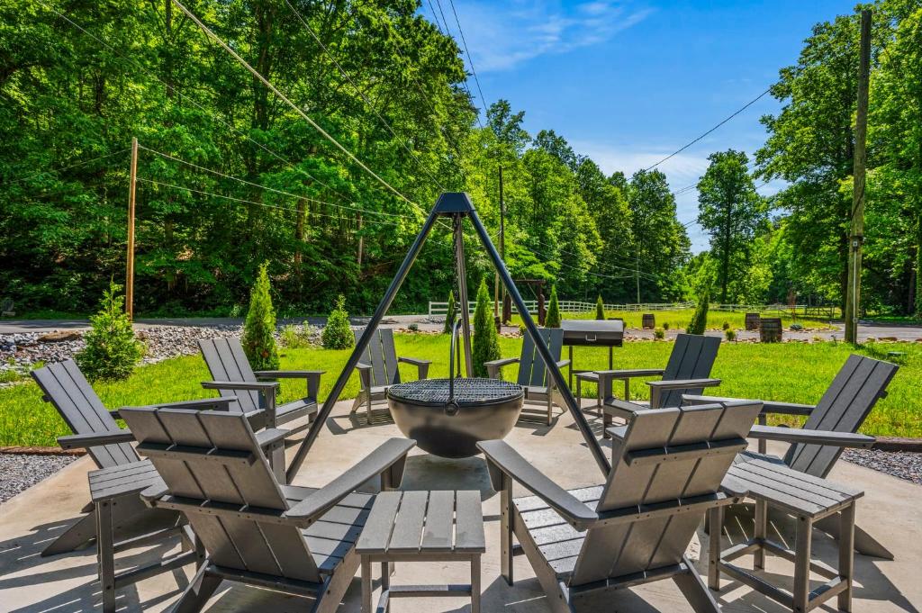 Adirondack chairs around the cowboy fire pit and its hanging bowl · © Camp Moonshine Retreat