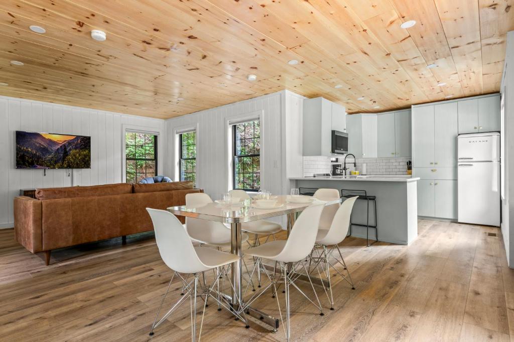 An open-plan living room and kitchen under a pine ceiling · © Camp Moonshine Retreat