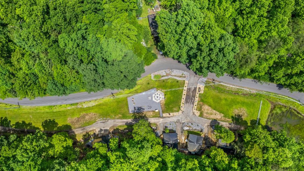 From above: the cabins, the fire-pit lawn and the pond at the edge · © Camp Moonshine Retreat