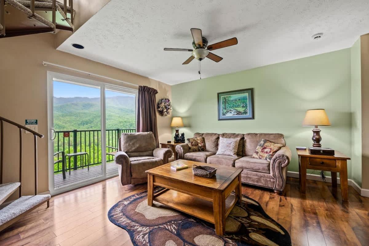 The living room opening to the balcony and the mountains beyond · © Above The Clouds