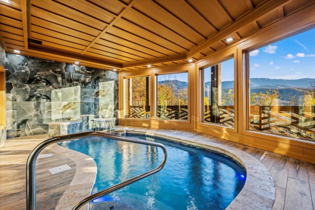 The indoor pool under a timber ceiling, windows onto the ridges · © Alpine Haven