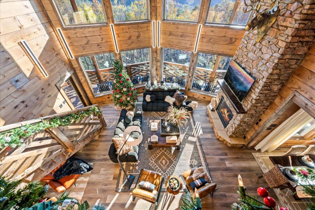 The great room from above: stone fireplace and a wall of glass · © Alpine Haven