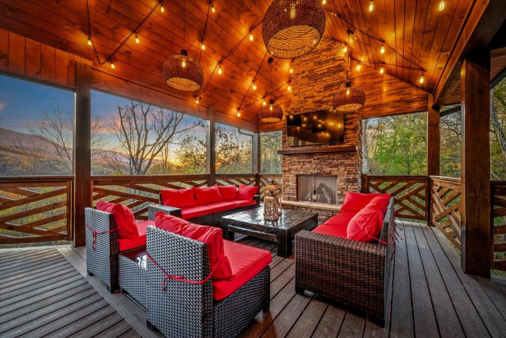 The covered porch with its stone fireplace and string lights · © Alpine Haven