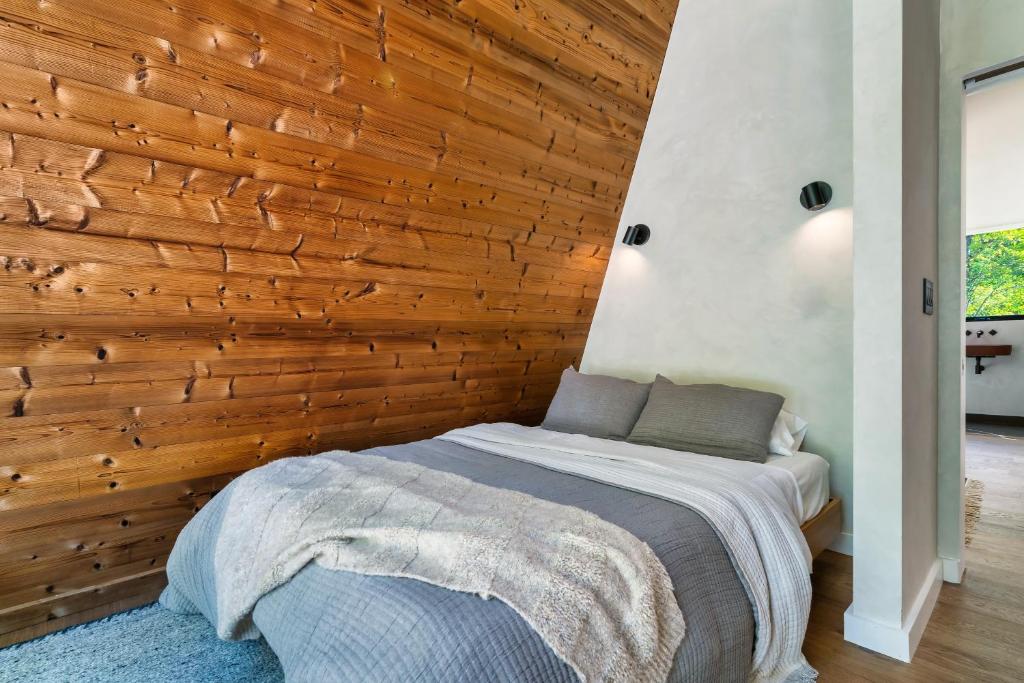 The bedroom against the timber slope of the A-frame · © An Escape to the Forest