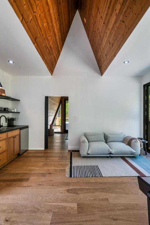 The living area and kitchen under a timber-lined ceiling · © An Escape to the Forest