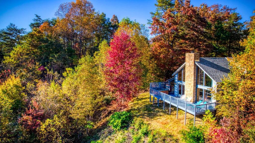 The cabin and its deck among the fall trees · © Barenberg Cabin