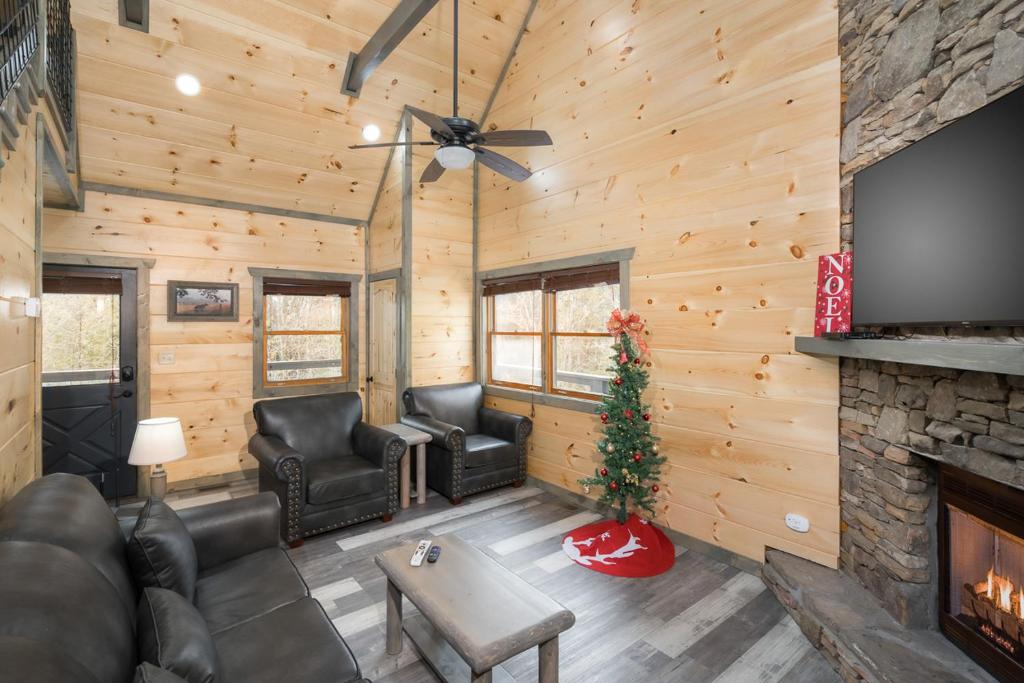 The living room around its stone-faced fireplace · © Bear Necessity