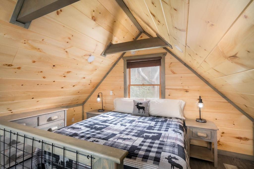 The king bed in the loft under a pitched pine ceiling · © Bear Necessity