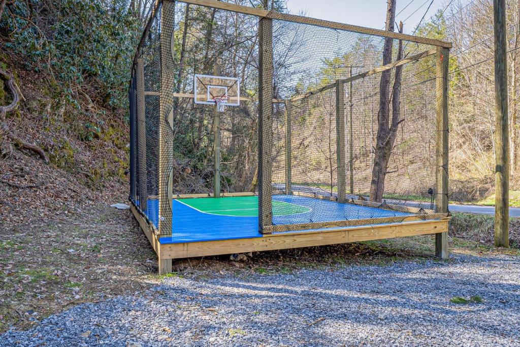 The fenced sport court in the yard, set for a game of basketball · © Bear Paradise Cabin