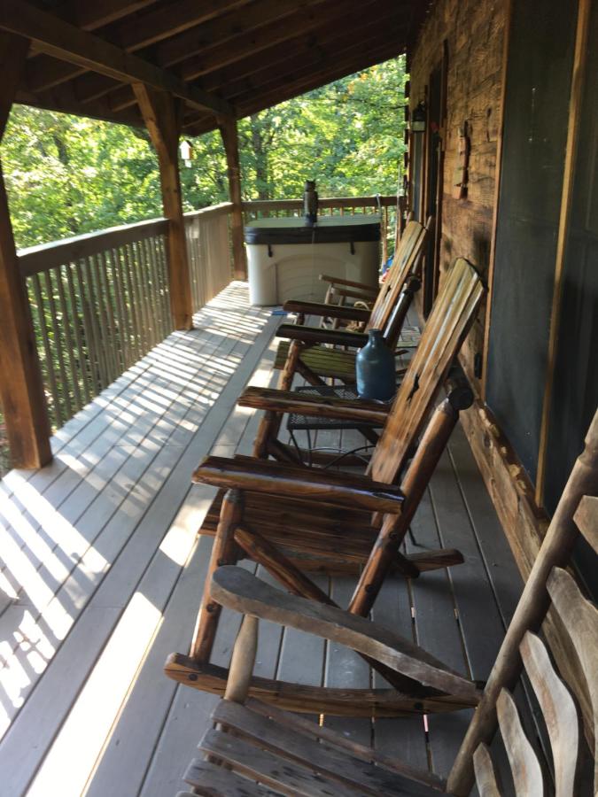 Rocking chairs and the private hot tub on the covered deck, deep in the trees · © Bears Among Us