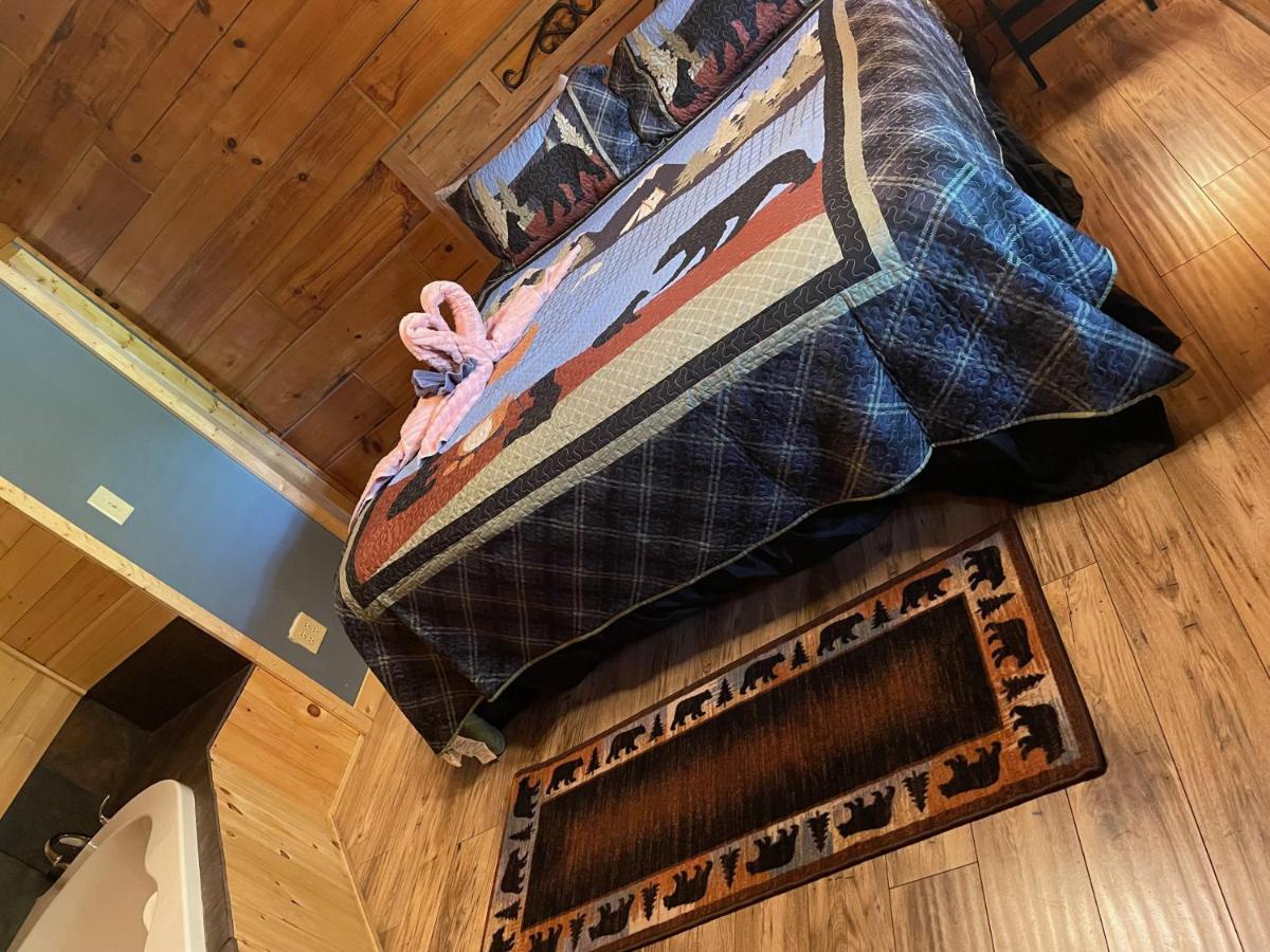 A bedroom under a Smoky Mountains quilt beside the spa tub · © Bears Among Us
