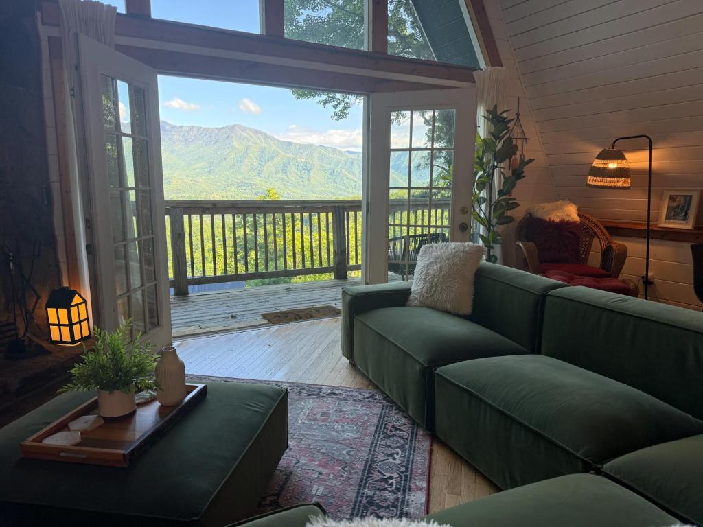 French doors open from the green sofa onto the deck and the ridge · © Little Green Cabin