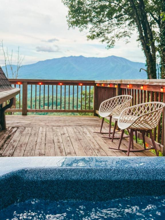 From the hot tub across the lit deck rail to the mountains · © Little Green Cabin