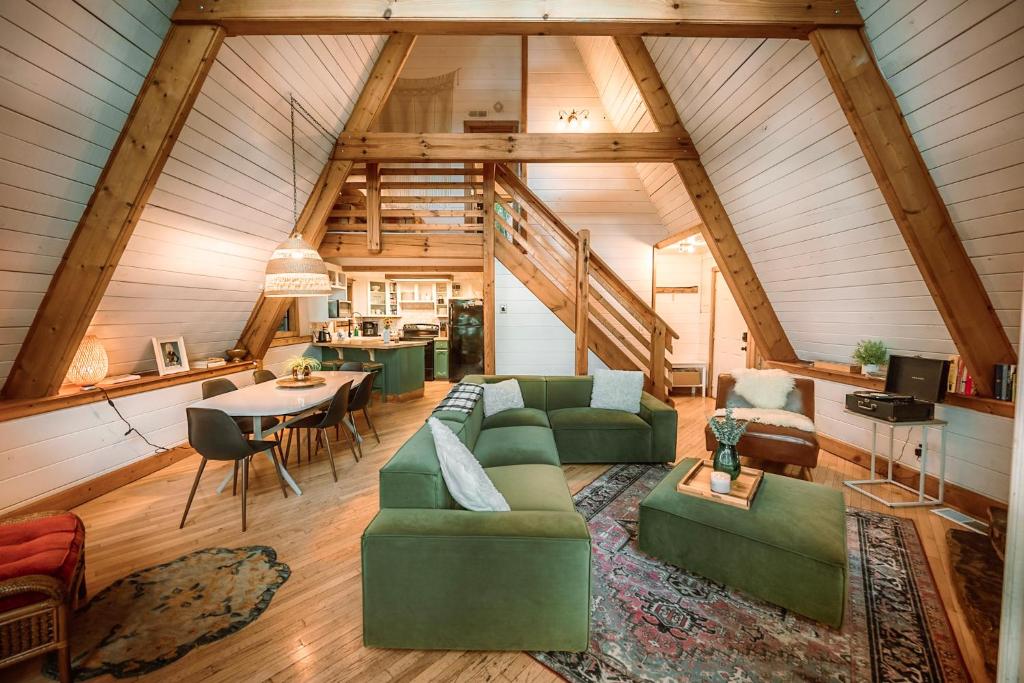 Living room, dining table and kitchen under the A-frame beams · © Little Green Cabin