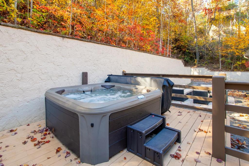 The private hot tub on the deck under the autumn treeline · © Bigfoot's Hideout