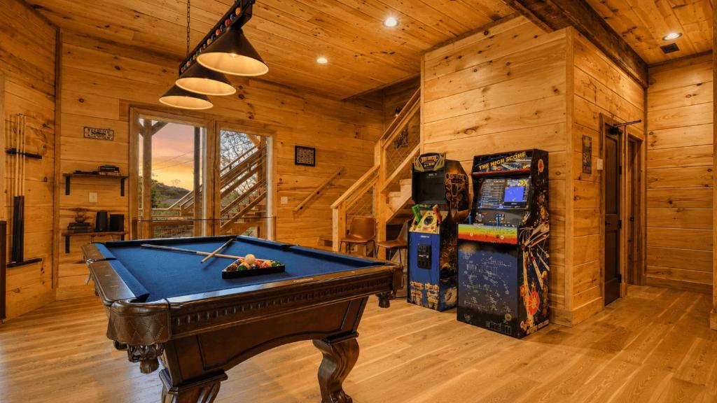 The game room: a pool table and arcade cabinets · © Birch Lodge