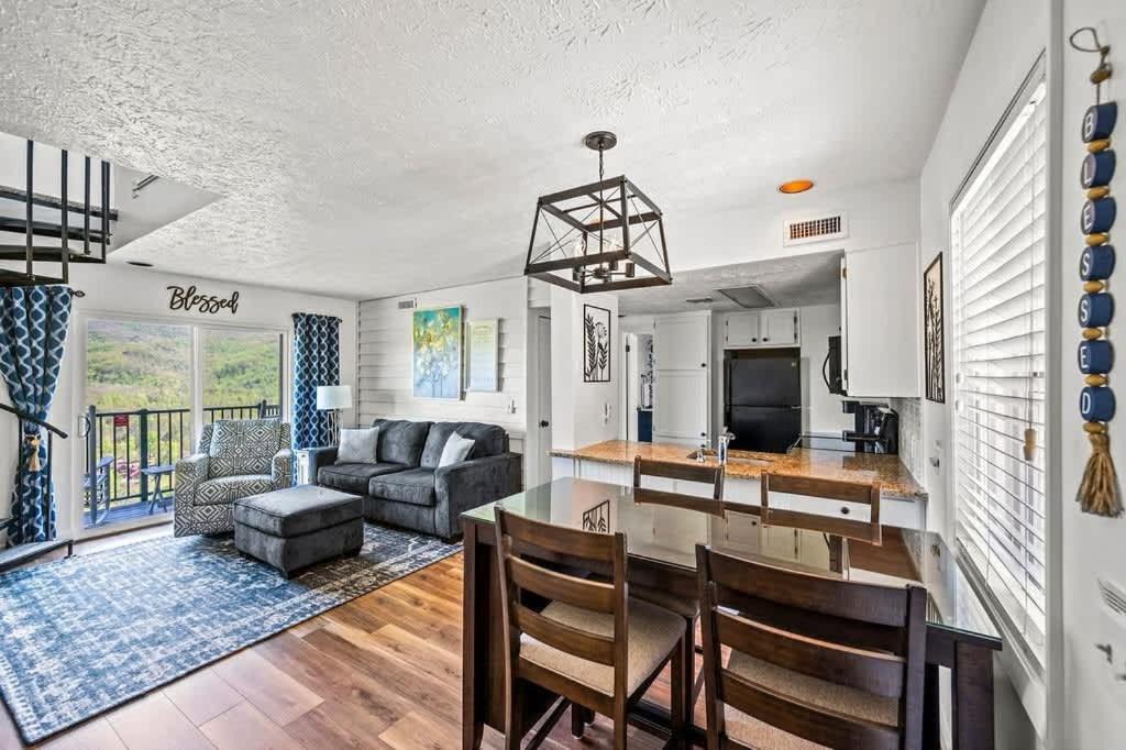 Open living and dining opening to the balcony and the ridge beyond · © Blessed in the Smokies