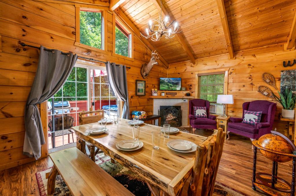 The log dining table by the fireplace, the deck just outside · © The Morning Mist Cabin
