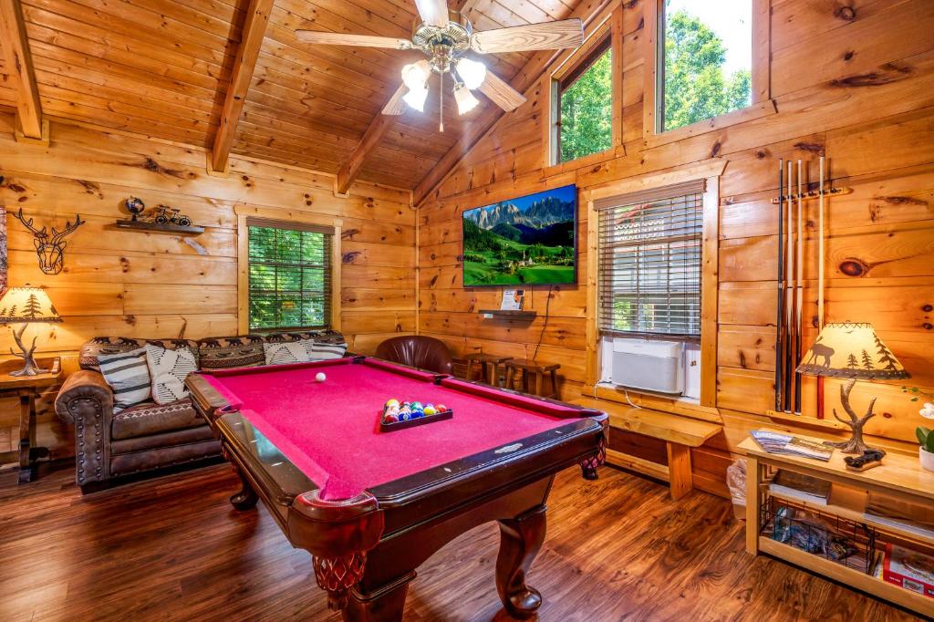 The pool table and sofa under the vaulted pine ceiling · © The Morning Mist Cabin