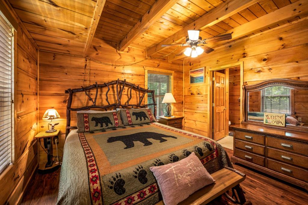 A bedroom with a twig headboard and a black-bear quilt · © The Morning Mist Cabin