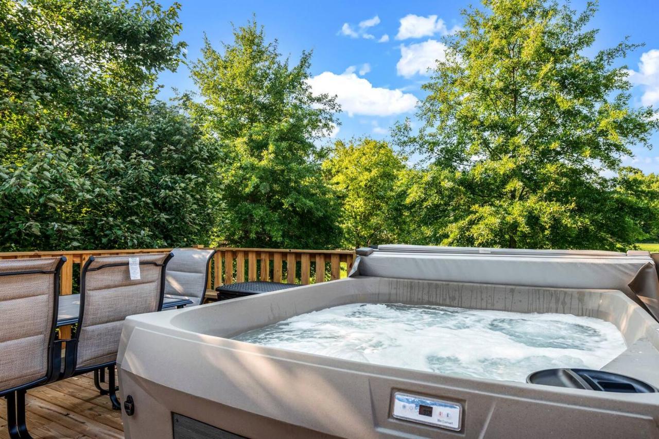 The hot tub on the tree-shaded back deck, with lounge chairs alongside · © Creekside Cottage