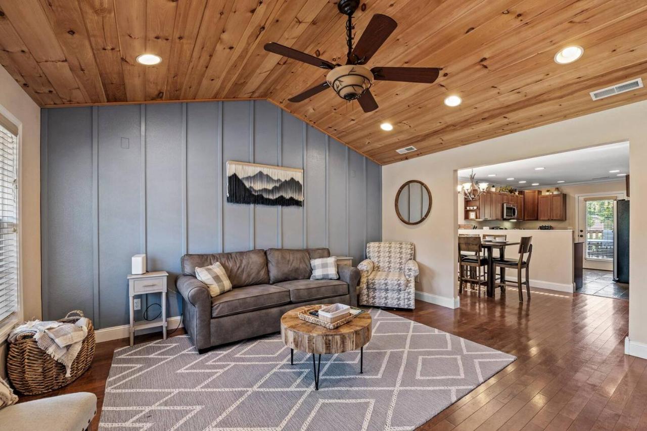 The open living room under a vaulted cedar ceiling, opening to the kitchen · © Creekside Cottage