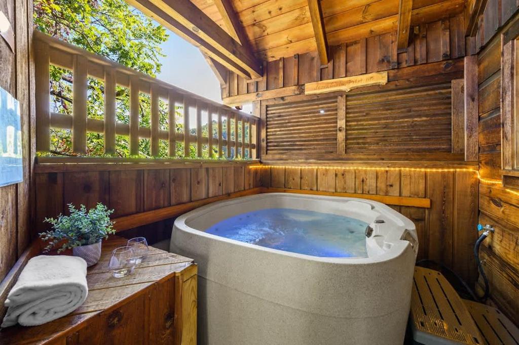 The hot tub behind wooden privacy screens on the porch · © Do Not Disturb