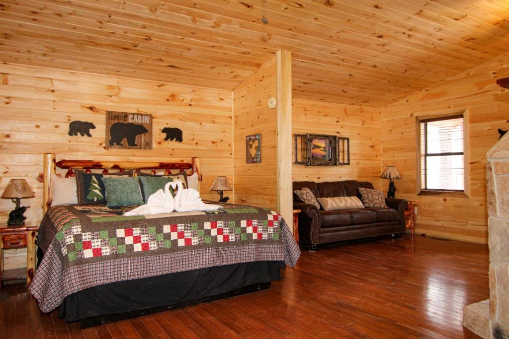 The king bed and leather sofa sharing the cabin's single open room · © Endless Mountain Dreams