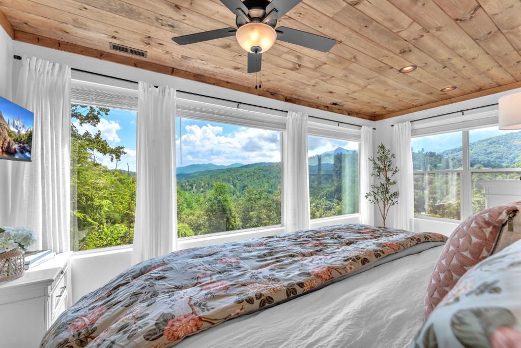 A bedroom wrapped in windows over the wooded ridges · © Bear Necessities