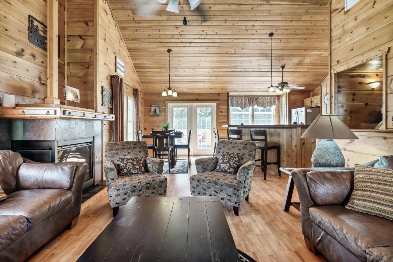 The open living room gathers leather seating around a stone fireplace · © Fireflies and Moonshine