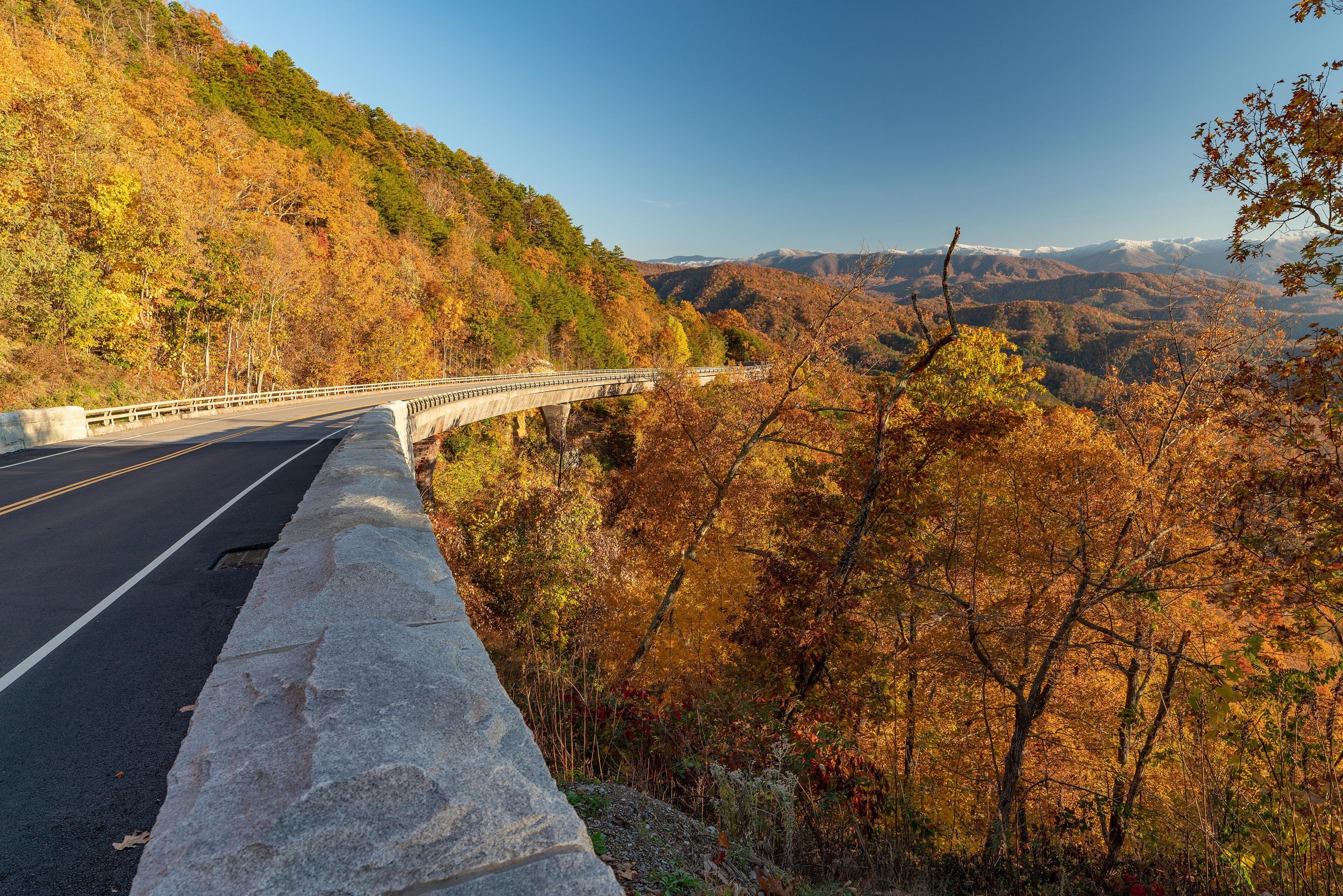 A parkway bridge above fall color, snow on the high ridges beyond