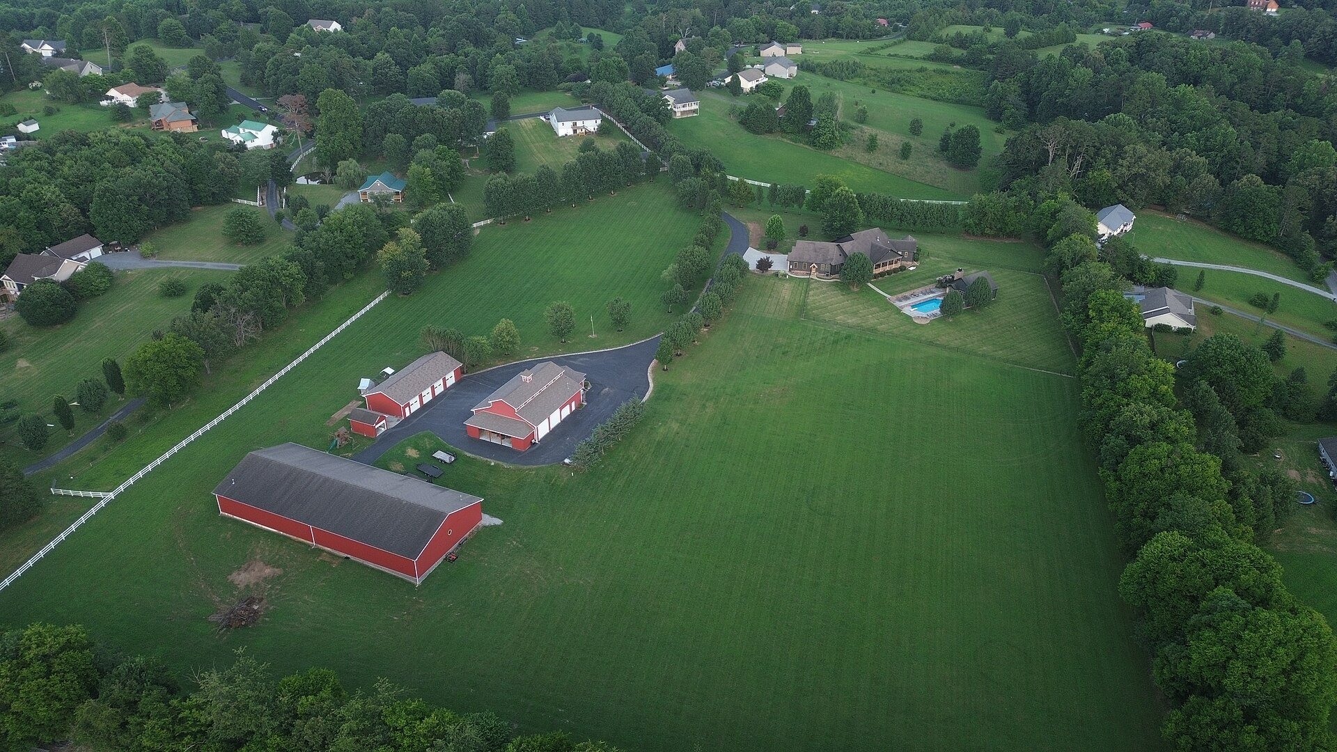 Red outbuildings and lawns in rural Sevier County, seen from above