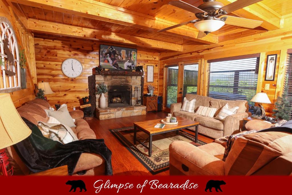 The great room with leather sofas and a stone-hearth fireplace · © Glimpse of Bearadise