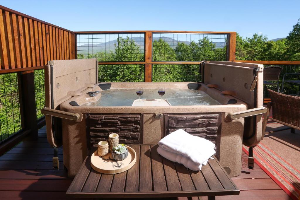 The deck hot tub set against the wooded ridgeline · © Glimpse of Bearadise