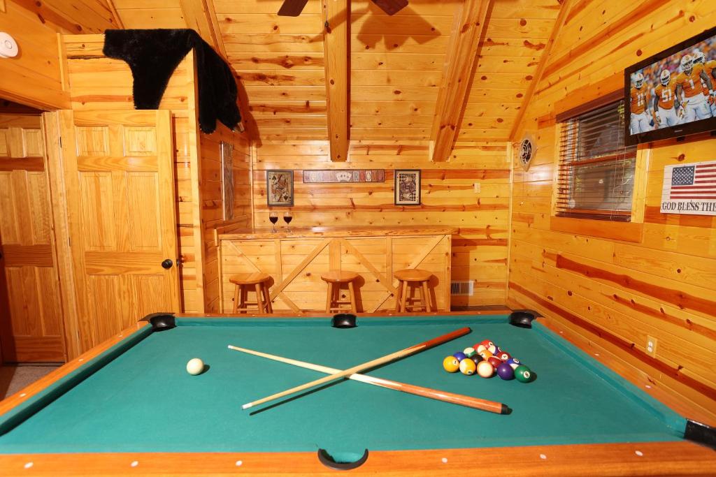 A downstairs game room with a pool table and bar seating · © Glimpse of Bearadise