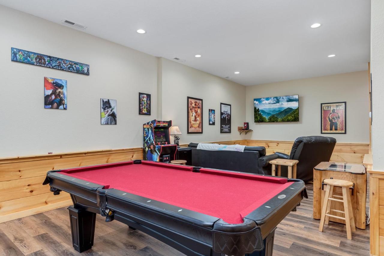The lower-level game room with a red-felt pool table and arcade cabinet · © Goats & Honey Family Cabin