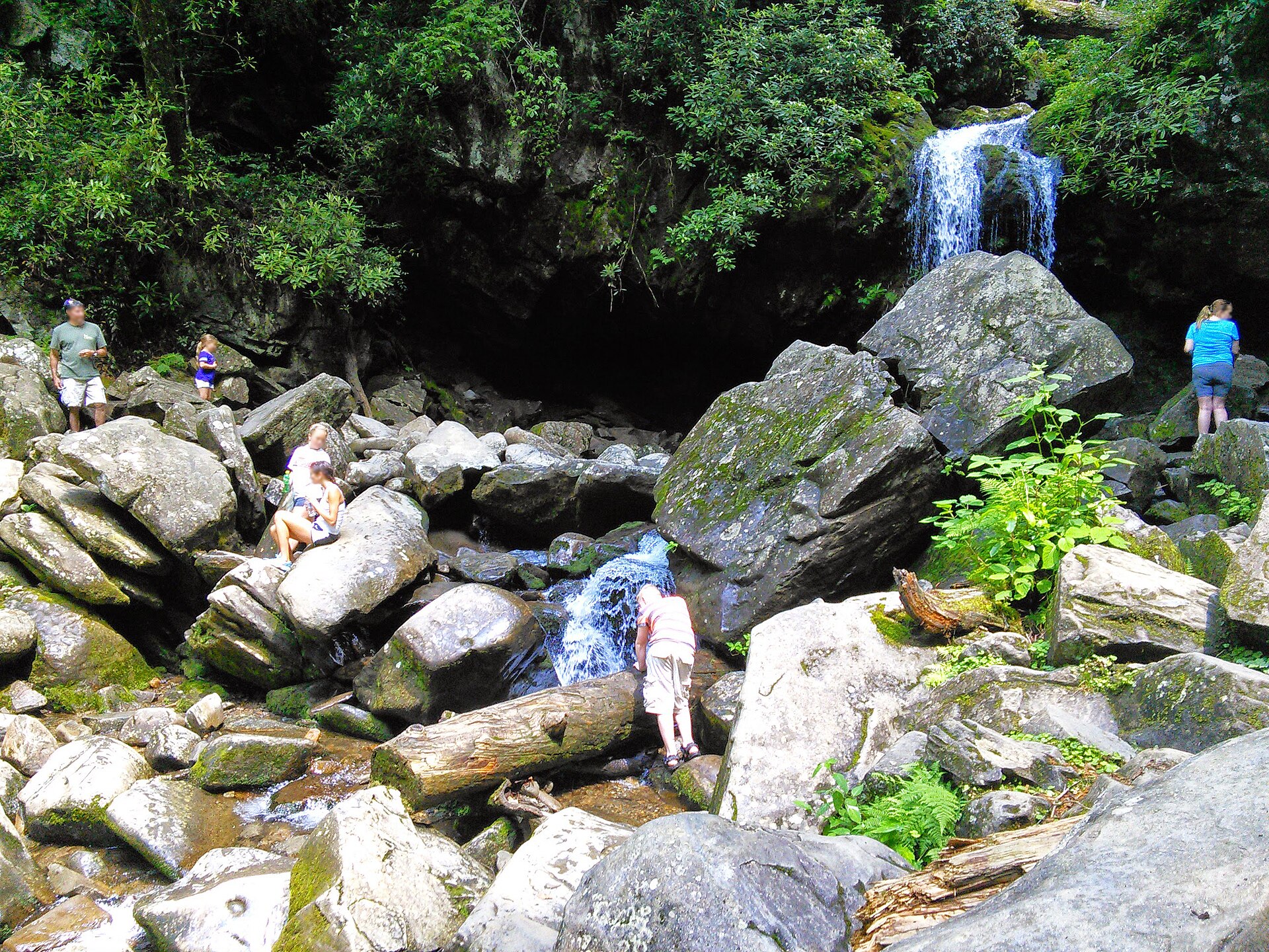 Hikers on the boulders below Grotto Falls on a June day