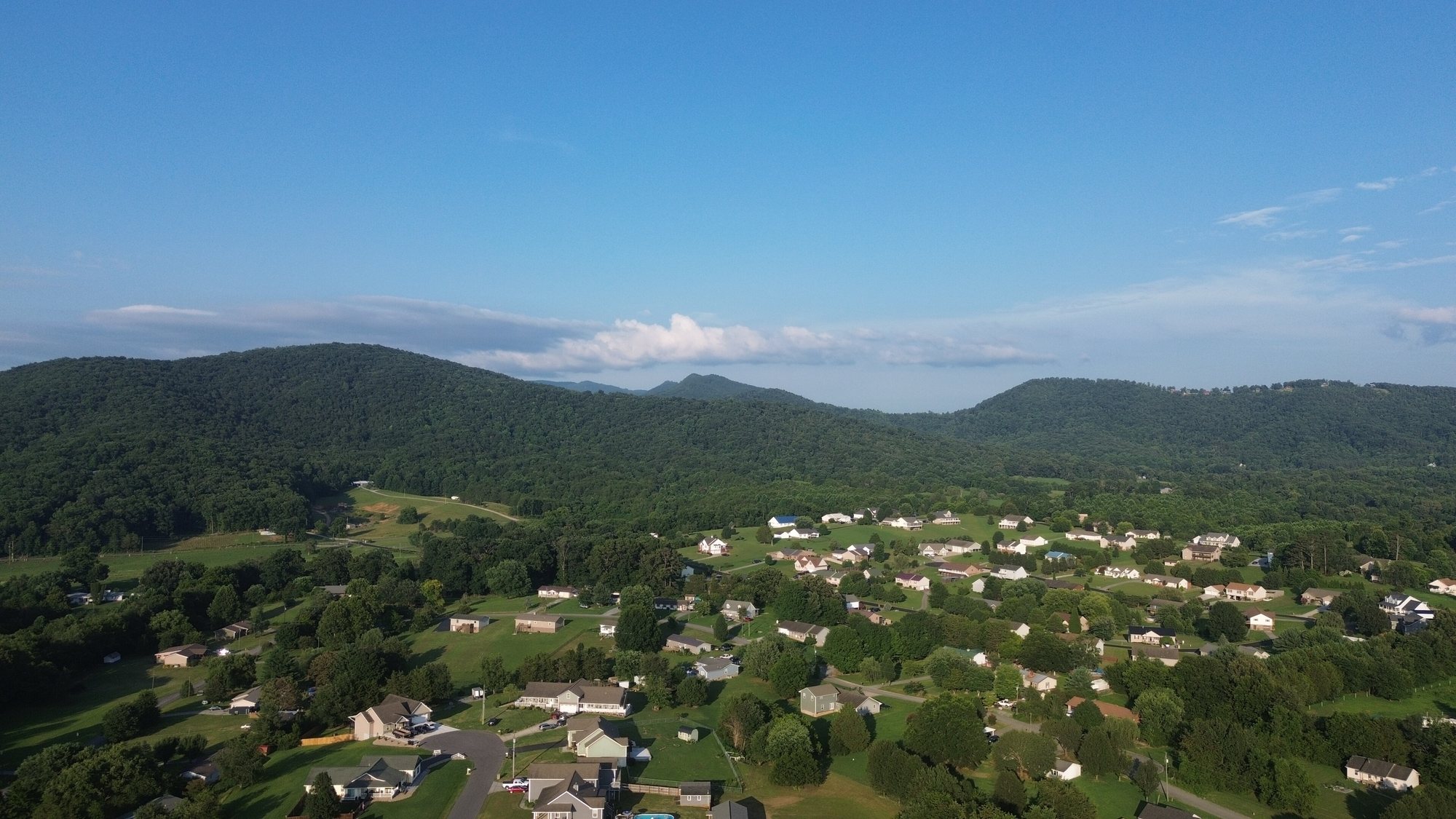 Forested foothills above farms and homes in rural Sevier County
