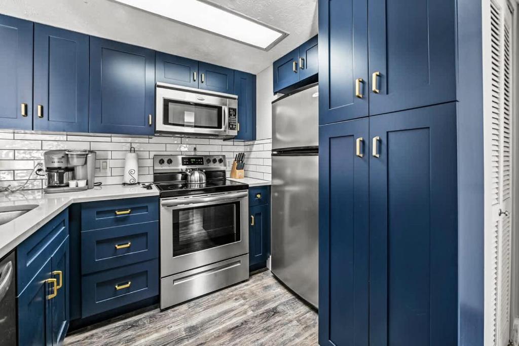 The navy-cabinet kitchen with a full-size oven and fridge · © Hesed Mountain Haven