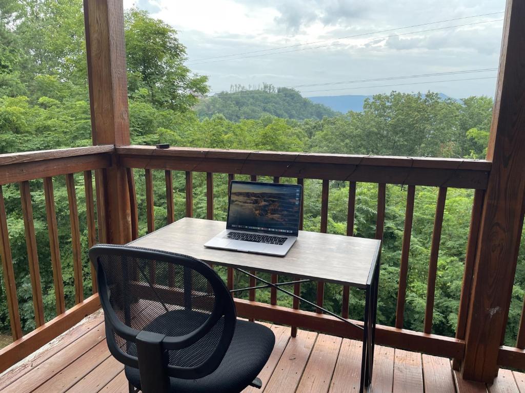 A work desk on the deck, facing a wooded ridge · © Honey Bear