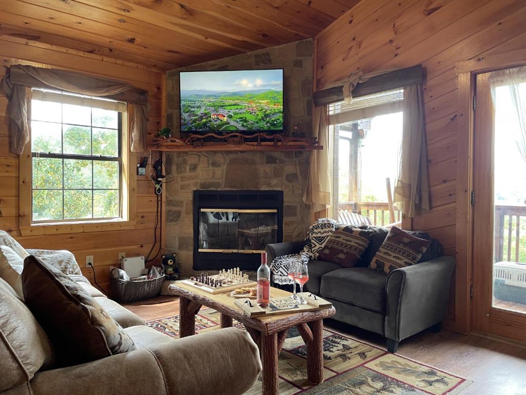 The living room around the stone fireplace, deck door open · © Honey Bear