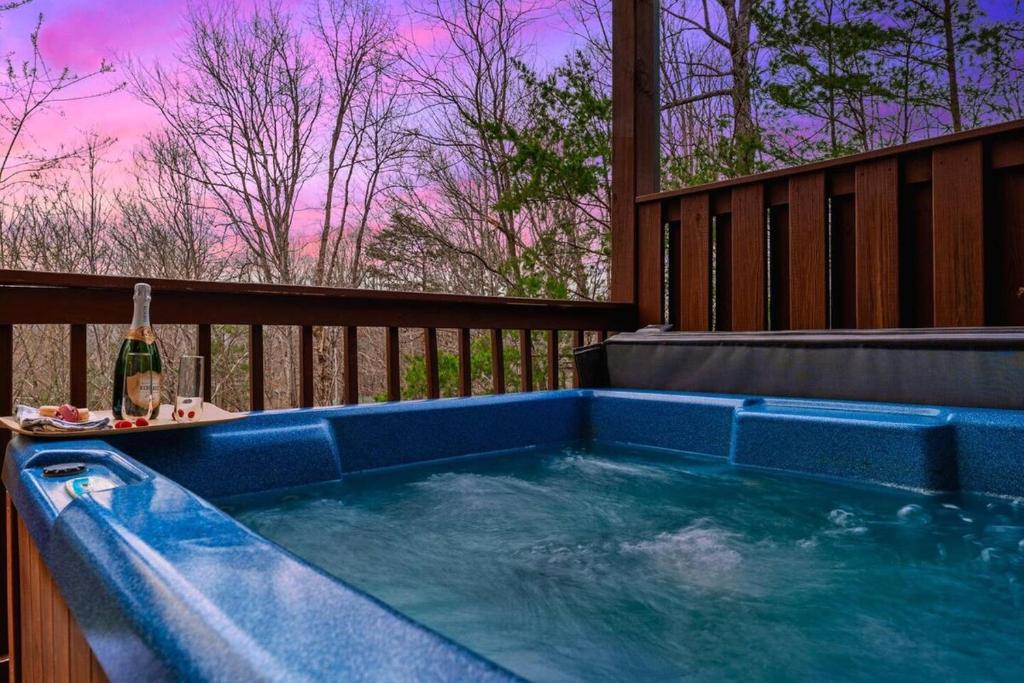 The private hot tub on the deck at dusk · © Honeymoon Cabin