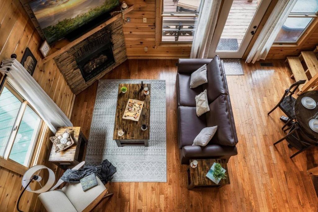 The great room with a stone fireplace, seen from the loft · © Honeymoon Cabin