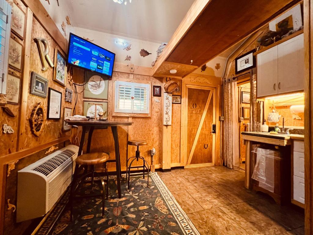 The living space, with bistro table, stools and wall-mounted TV · © Jones Cove Tiny House