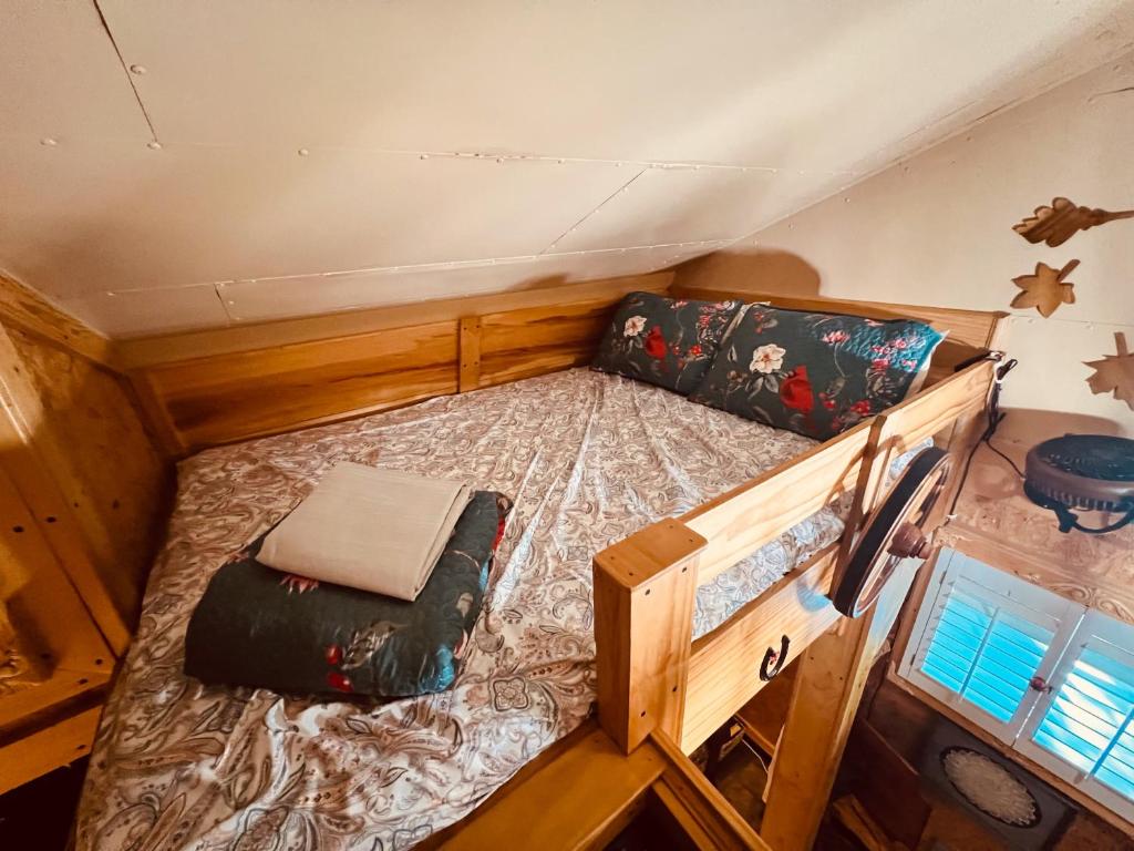 The full bed in the loft, under the sloped ceiling · © Jones Cove Tiny House