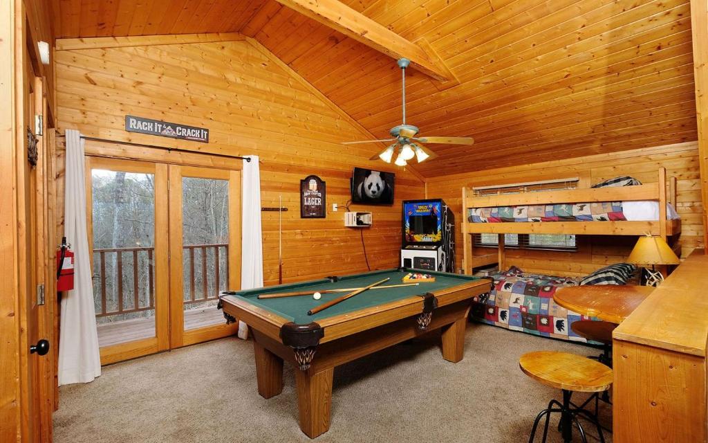Pool table, arcade cabinet and a bunk bed in the game room · © Knotty Escape