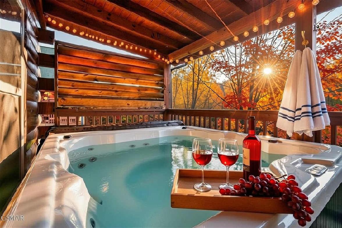 The covered-deck hot tub glowing under string lights as the maples turn · © Lazy Bear Lodge
