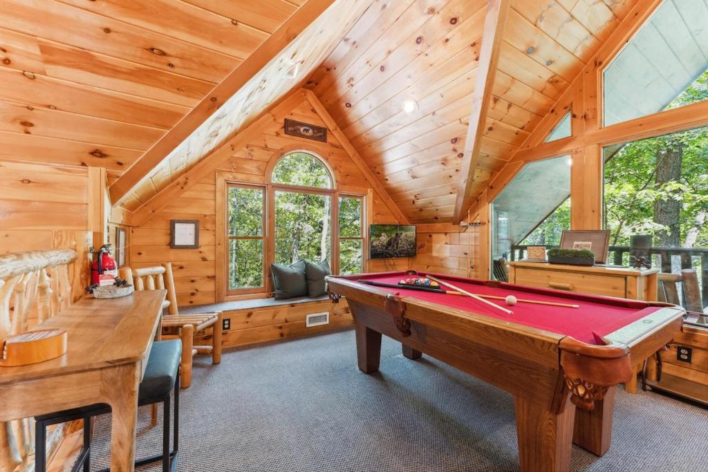The loft game room with a pool table beneath the vaulted pine ceiling · © Little Pine Lodge