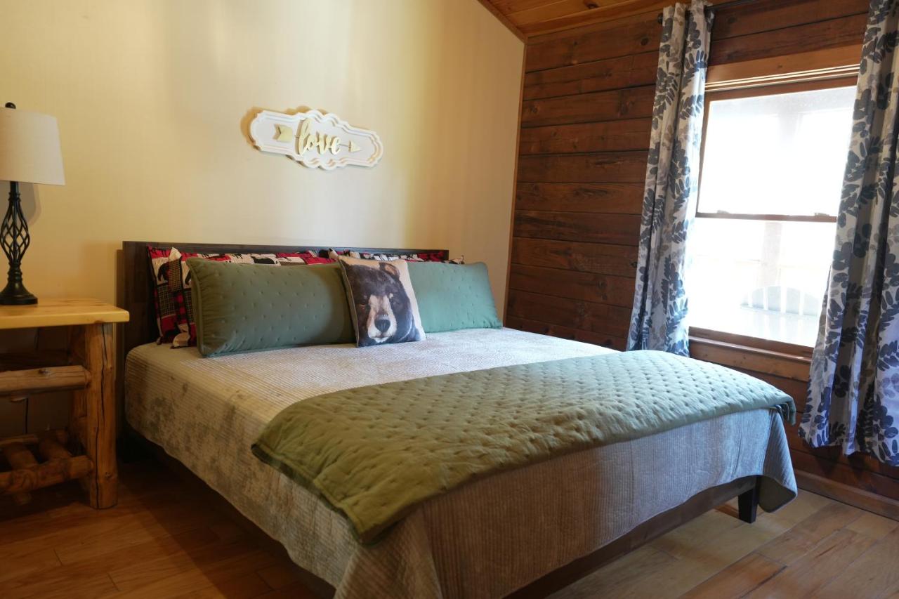 The king bed beneath a wooden love sign · © Love Shack