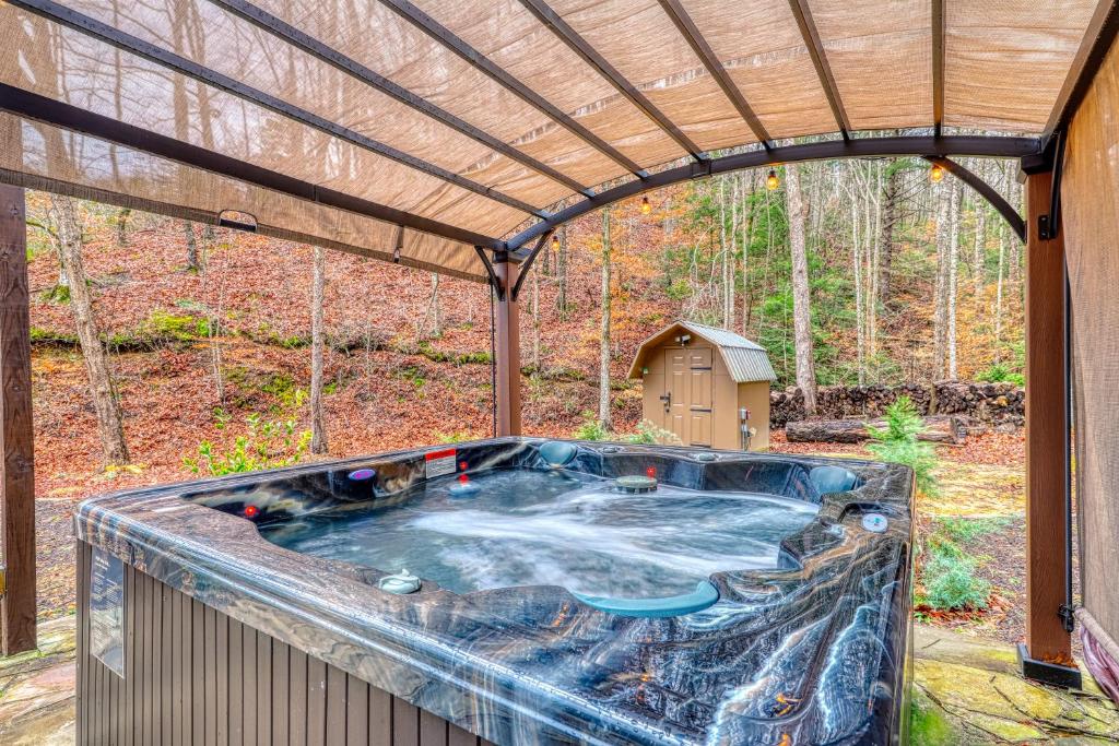 The hot tub under its canopy, facing the woods · © Mill Creek Tiny House